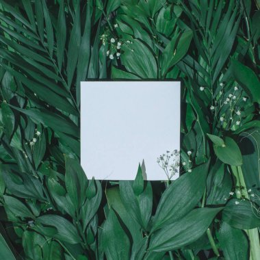 Çiçeklerden ve kağıt kart notlu yapraklardan oluşan yaratıcı bir düzen. Düz yatıyordu. Doğa konsepti