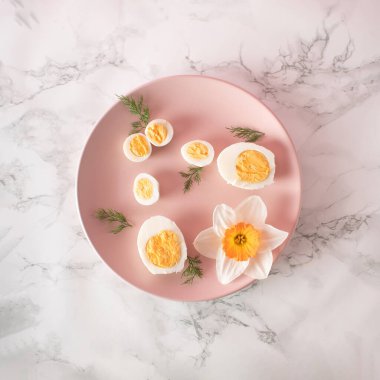 Haşlanmış tavuk ve bıldırcın yumurtası ve mutfak mermer arka planında pembe tabakta narsis. Sağlıklı çiğ gıda konsepti