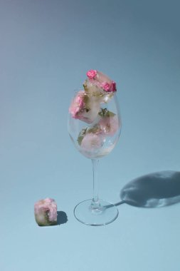 Mavi zemin üzerinde şeffaf camlar içinde güzel pembe çiçekler ve fotokopi alanı. Güneşli gün konsepti