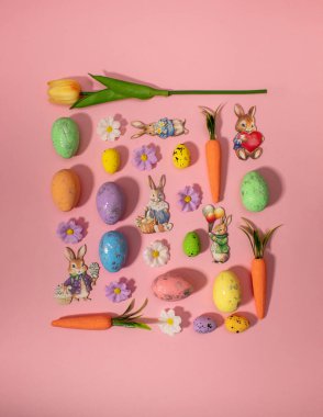 Renkli çiçeklerden, yumurtalardan, tavşanlardan ve havuçlardan oluşan paskalya deseni. Minimum tatil konsepti. Düz uzanma deseni.