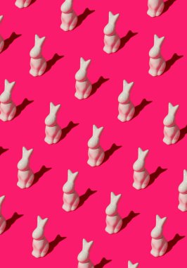 Paskalya tavşanlarının pembe arka plandaki desenleri. Minimalist izometrik konsept.