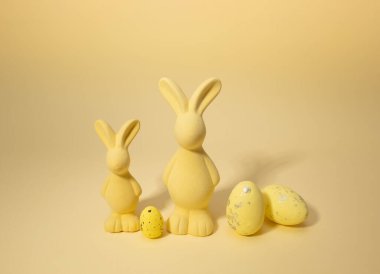 Sarı arka planda sarı Paskalya tavşanları ve yumurtalar. Mutlu Paskalya monokromatik konsepti