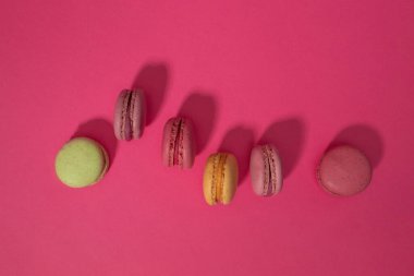 Pembe bir arka plan üzerinde renkli kurabiye kek. Düz yatıyordu.