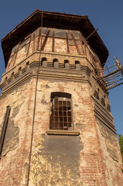 Soyulmuş alçılı eski hasarlı duvar, kırmızı tuğlalar ayrıntı ve pencere, kırsal bir kentsel arkaplan