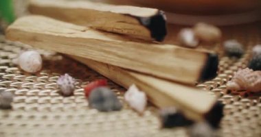 Palo santo ağacı sopaları ve deniz kabukları altın bir peçetede. Aromaterapi. Arınma. Yavaş çekim yatay çekim. Yakın plan.. 