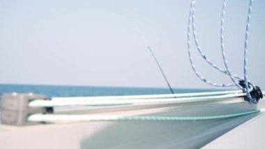 Yeşil ve mavi ipler katamaranda rüzgarda sallanıyor. Donanım. Güm güm. Denizde güçlü bir rüzgar. Gökyüzü açık. Koyu mavi su. Bir katamaran üzerinde yelken açmak.