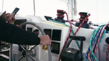 Kaptan, Kaptan 'ın köprüsündeki katamaranın direksiyonunda. Ellerini direksiyona koy. Tekne gezisi. Bir katamaran üzerinde yelken açmak. Uzun vinç. Bir gezinme panelinde pusula. 