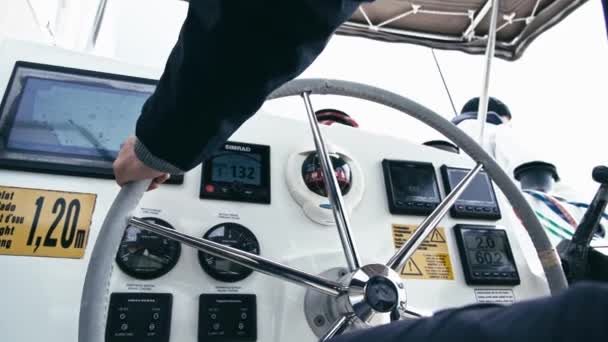 スキッパーがカタマランを操縦する ステアリングホイール上のスキッパーの手のクローズアップ ナビゲーションパネルとステアリングホイールのクローズアップ カタマランでの航海 — ストック動画
