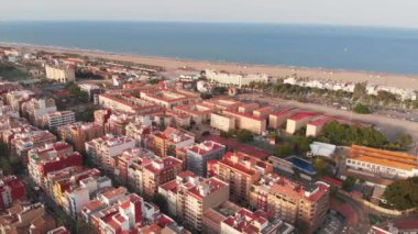 Günbatımında Valencia Cabanyal bölgesinde hava manzarası. Cabanyal ve Malvarrosa sahillerinin tepeden tırnağa manzarası. Valencia 'nın evlerinin hava görüntüleri. 4K.