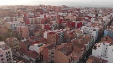 Valencia 'nın evlerinin üzerinde bir panorama. Dinamik çekim. Gün batımında çekildi. Valencia 'nın mimarisi. 4K.
