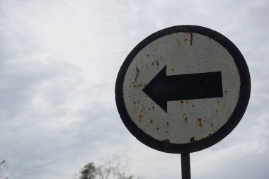 Caddedeki eski tip trafik levhası, aracın kopyalama alanı ile sola dönmesi gerektiğini gösteriyor