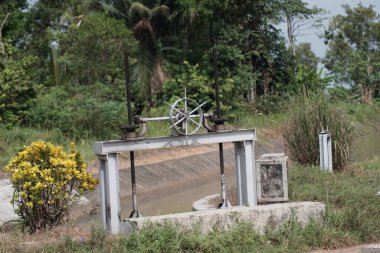 Sulama kanallarının kapaklarındaki suyun boşaltımını düzenlemek için bir araçName