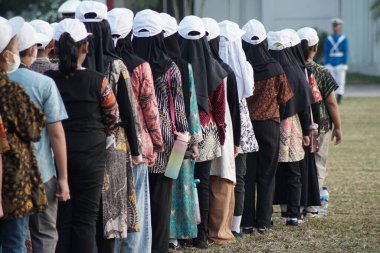 Endonezyalı ilkokul öğrencileri Endonezya 'nın bağımsızlık gününde bayrak kaldırma töreninde batik ve beyaz şapka kullanıyorlar.