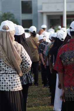 Endonezyalı ilkokul öğrencileri Endonezya 'nın bağımsızlık gününde bayrak kaldırma töreninde batik ve beyaz şapka kullanıyorlar.