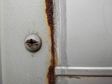 Paslı cıvatalı paslı bir kapı kolu.