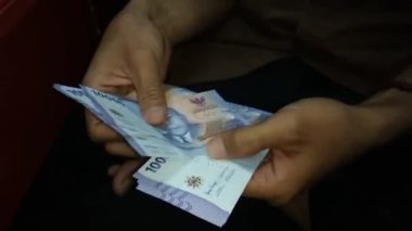 Endonezyalı adamın para sayma görüntüsü. kırpılmış görünüm