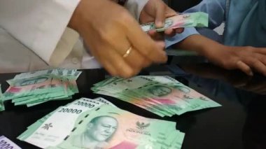 Kadınların para sayma görüntülerine yakından bakın.