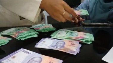 Kadınların para sayma görüntülerine yakından bakın.