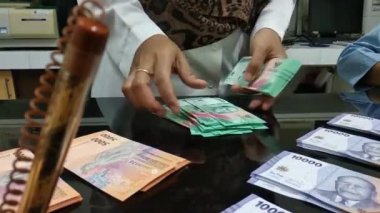 Kadınların para sayma görüntülerine yakından bakın.