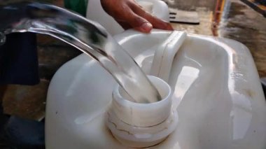 Benzin bidonuna taze su dökerken yakın çekim görüntüsü