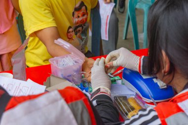 Lampung Tengah, Lampung, Endonezya - 7 Aralık 2024: Bir sağlık çalışanı Lampung, Endonezya 'da bir kan bağışı sırasında kan örneği alıyor