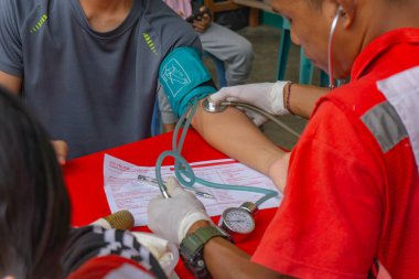 Lampung Tengah, Lampung, Endonezya - 7 Aralık 2024: Bir sağlık çalışanı kan bağışı yapan birinin kan basıncını kontrol ediyor, Lampung, Endonezya 'daki bir etkinlikte.