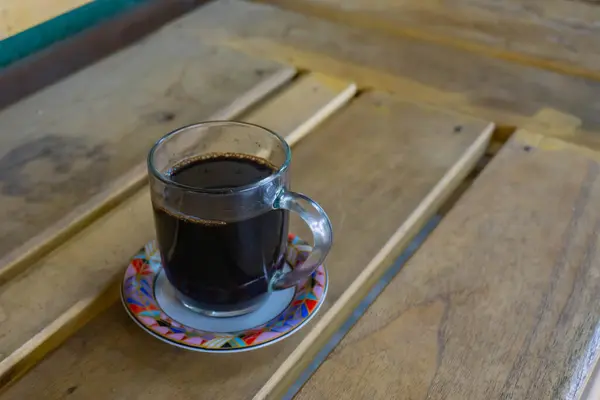 Tahta masada bir fincan koyu kahve.