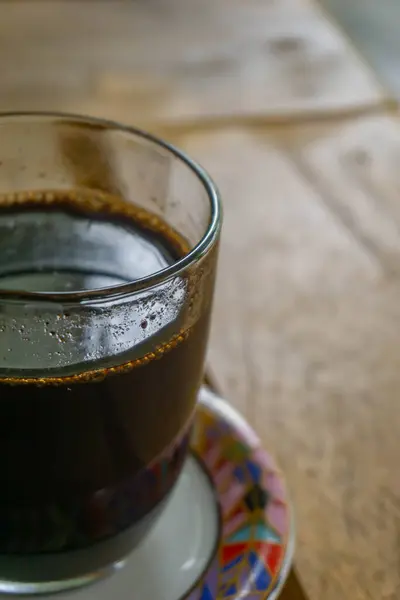 Tahta masada bir fincan koyu kahve.