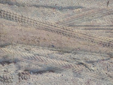 Toprak yolda bot ve motosiklet lastik izleri var. soyut arkaplan