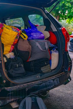 Bir yolculuk hazırlığı için bagajda çeşitli çantalar ve eşyalar var.