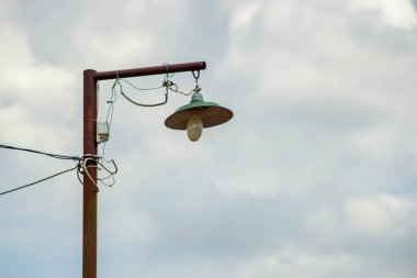 Bulutlu bir gökyüzü olan eski sokak lambası