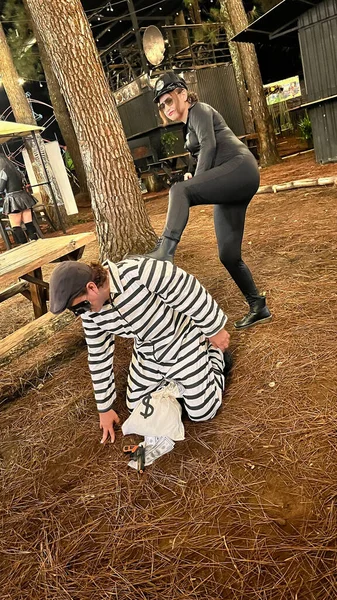 stock image couple dressed as police woman and prisoner, doing arrest poses