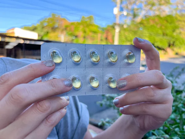 close up of female hands, holding a blister pack of capsules. blister pack of vitamin capsules.