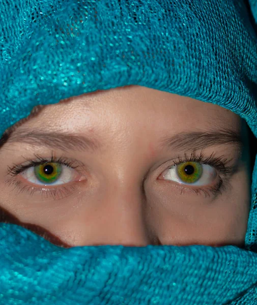 green-eyed girl with her face wrapped in a green turban. close up of a girl with beautiful green eyes wearing a green hijab