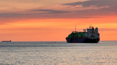 Güzel bir gün batımı ve ufukta bir gemi. Denizde altın saat