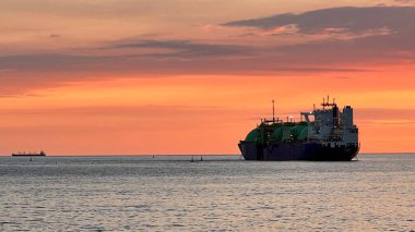 Güzel bir gün batımı ve ufukta bir gemi. Denizde altın saat