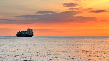 Güzel bir gün batımı ve ufukta bir gemi. Denizde altın saat