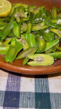 İnga edulis tohumları, limon ve tuzla birlikte kil bir tabakta servis edilen egzotik meyveler. Genel olarak: guama, guaba, pacae veya pacay