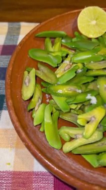 İnga edulis tohumları, limon ve tuzla birlikte kil bir tabakta servis edilen egzotik meyveler. Genel olarak: guama, guaba, pacae veya pacay