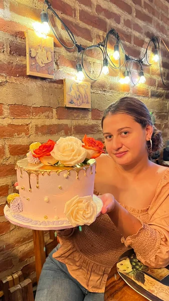 Elinde pasta olan güzel bir genç kadın. Elinde pasta olan bir kız. Güllü kek. gerçek hayat kavramı