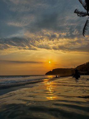 Gün batımında yüzme havuzunda dinlenen genç bir kadın. Güzel tropikal plaj. El Salvador 'da
