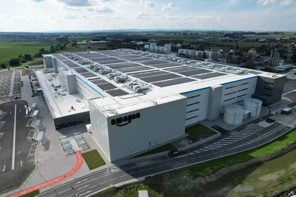 KOJETIN, Çek Cumhuriyeti-24 Eylül 2022: Gıcır gıcır yeni bir Amazon Deposu dağıtım merkezi. Büyük çaplı lojistik merkezi, Avrupa, Kojetin Çek güneş enerjisi santralinin havadan görüşü ve dağıtımı
