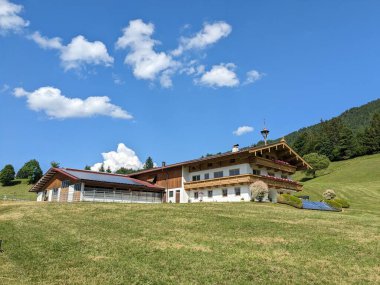 Kossen, Avusturya-12 Haziran 2023: Avusturya 'nın manzaralı dağlarında geleneksel yerel stil evi, tarım