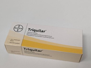 Prague, Czech Republic - July 10 2024: Triquilar box of medication with levonorgestrel and ethinylestradiol active substances by Bayer, used for contraception and menstrual regulation. clipart