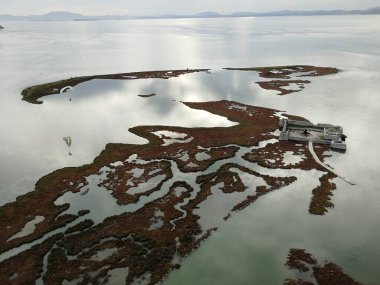 Arnavutluk kıyı şeridi boyunca uzanan mavi deniz ve kumlu plajlar üzerinde yamaç paraşütü manzarası, kıyı manzarası, turizm ve açık hava sporları faaliyetlerini yakalıyor