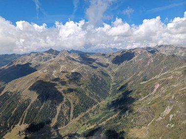 Julian Alplerinde özgürce uçmanın güzelliği, kümülüs bulutlarının bulutlu tabanında uçan büyük dağlar, manzaralı hava manzarası, Slovenya Soca nehir vadisi Avrupa