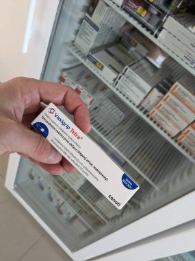 Prag, Çek Cumhuriyeti - 14 Ekim 2023: Eczane kavramı-Vaxigrip tetra aşı paketi bir buzdolabı eczacısının elinin önünde. Bu aşı sizi veya çocuğunuzu gribe karşı korumaya yardımcı olur (grip).)