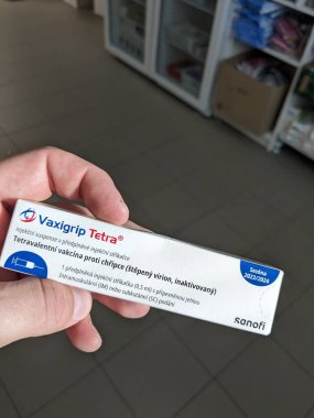 Prag, Çek Cumhuriyeti - 14 Ekim 2023: Eczane kavramı-Vaxigrip tetra aşı paketi bir buzdolabı eczacısının elinin önünde. Bu aşı sizi veya çocuğunuzu gribe karşı korumaya yardımcı olur (grip).)