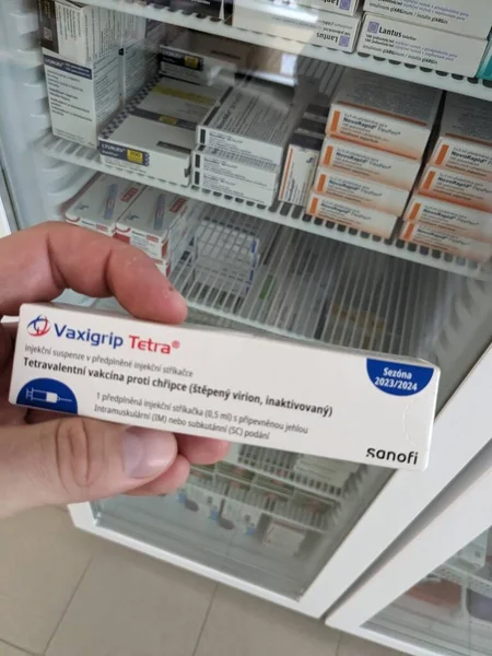 stock image Prague,Czech republic- October 14 2023:Pharmacy concept-Vaxigrip tetra vaccine package infront of a fridge ina  pharmacist hand.This vaccine helps to protect you or your child against influenza (flu)