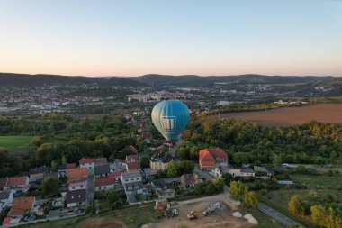 Sıcak hava balonu Beroun şehir kırsalında alçaktan uçuyor, manzaranın havadan manzarasını sunuyor..